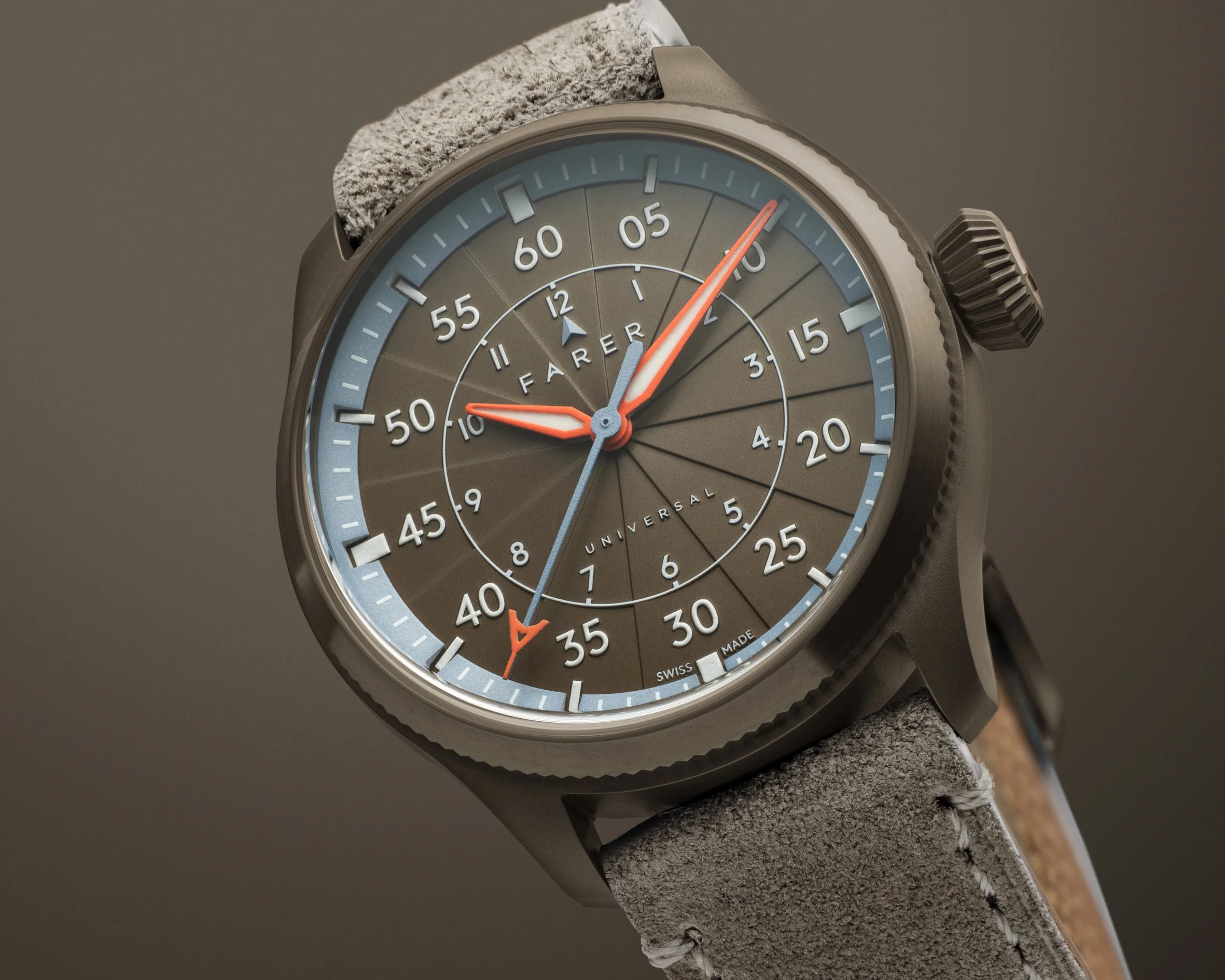 Close-up of a Farer Universal watch with a brown dial, orange hands, and a textured gray leather strap.