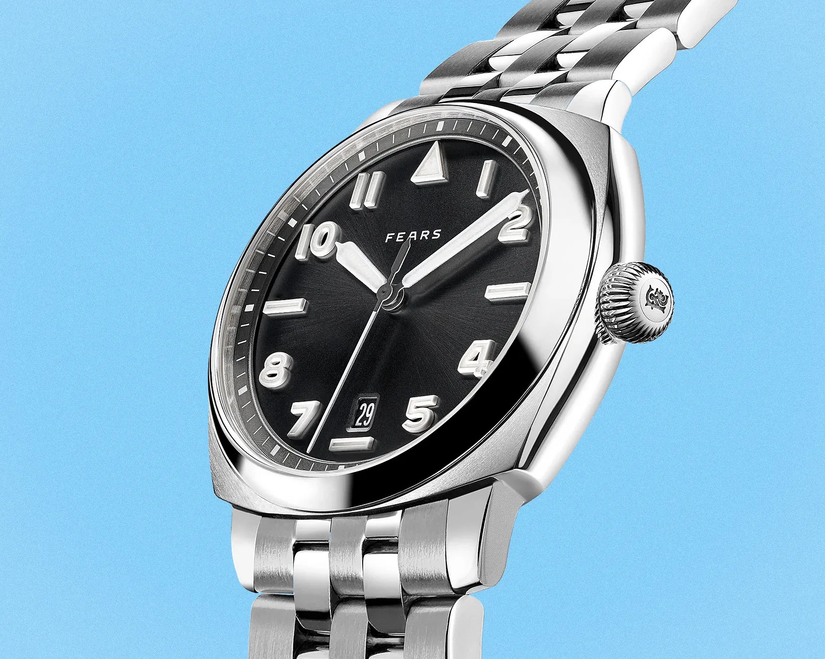 Silver metal wristwatch with black dial, white numerals, and date display on a light blue background.