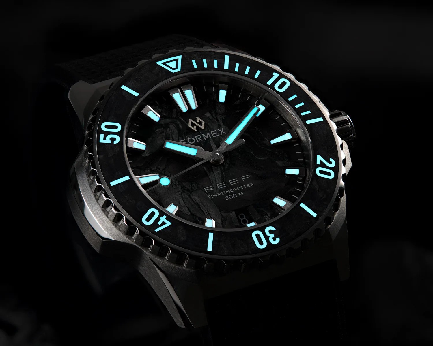 Black Formex Reef chronometer watch with glowing blue hour markers and hands on a black strap.