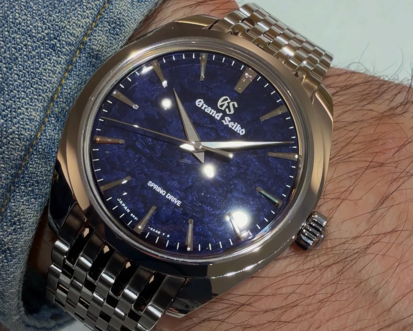 Grand Seiko wristwatch with a textured deep blue dial, silver hour markers, and a stainless steel bracelet.