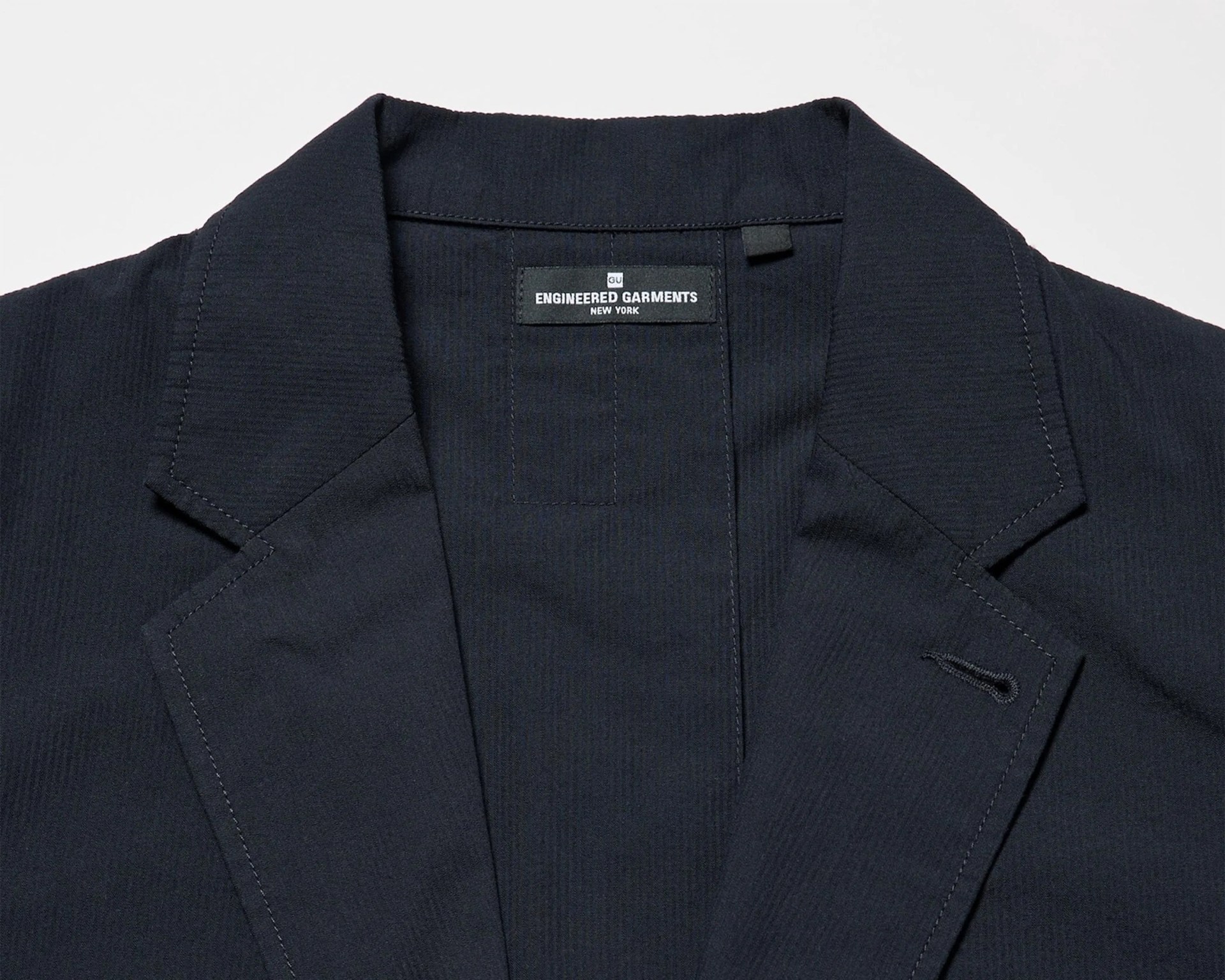 Close-up of a black blazer collar with a label reading "Engineered Garments New York.