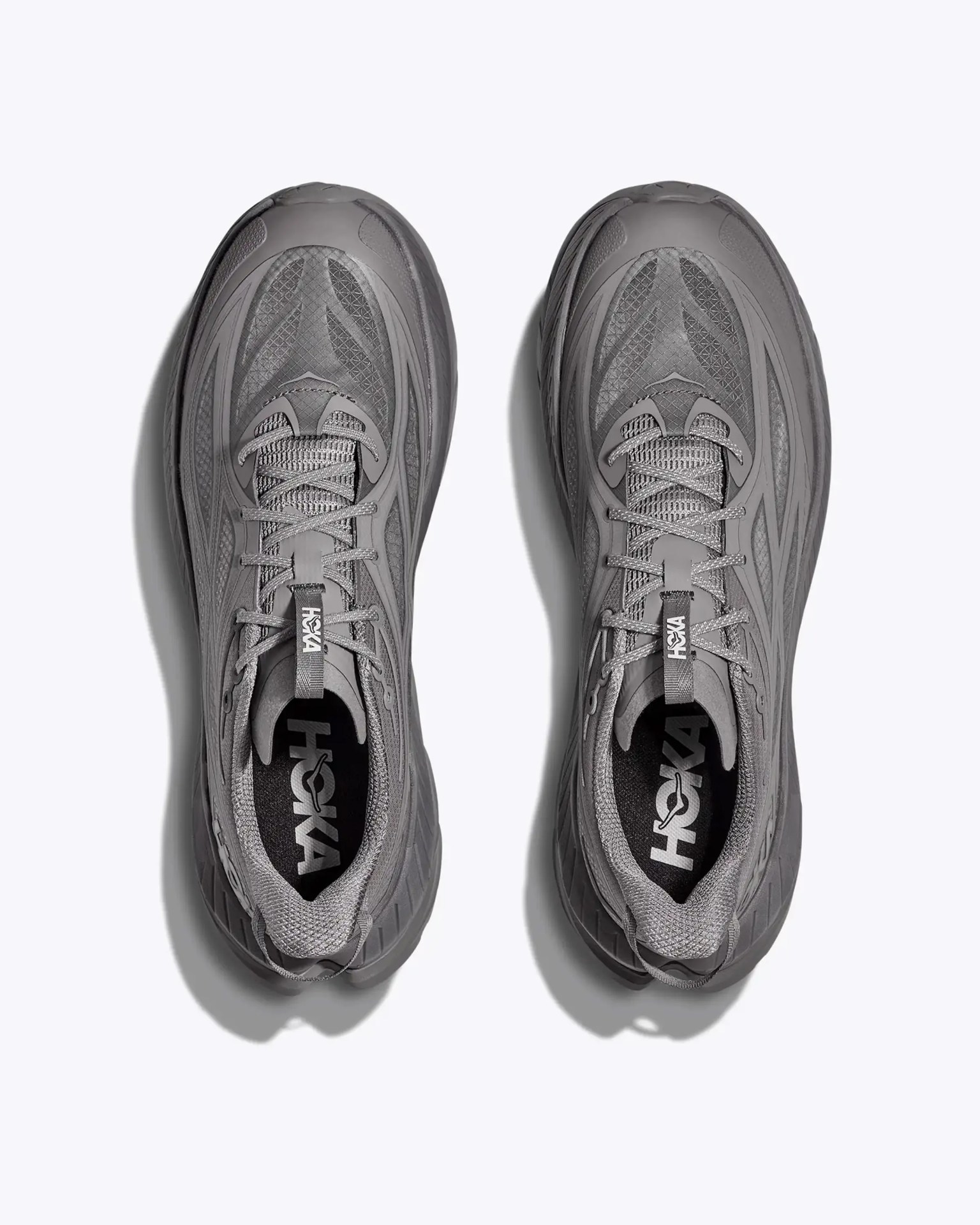 Pair of gray Hoka running shoes with mesh uppers and laces, viewed from above on a white background.