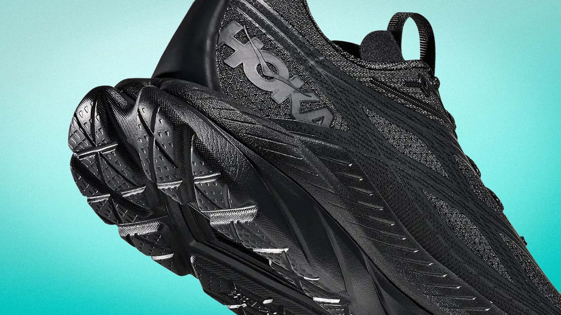 Black Hoka running shoe with textured sole and mesh upper against a teal gradient background.