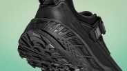 Close-up of the black rugged sole and heel of a trail running shoe with textured grip and synthetic upper.