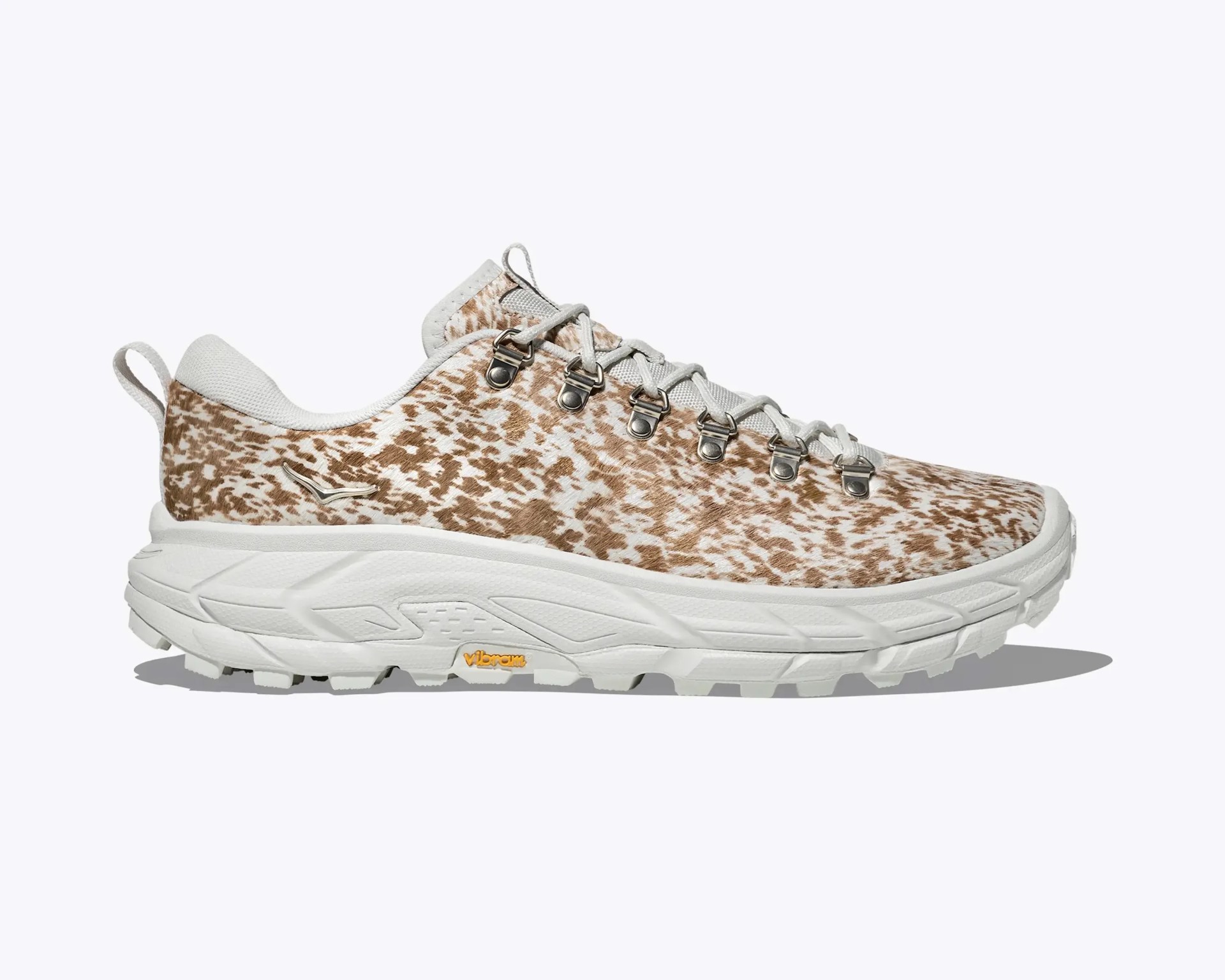 White and tan speckled hiking shoe with metal eyelets and thick Vibram sole.