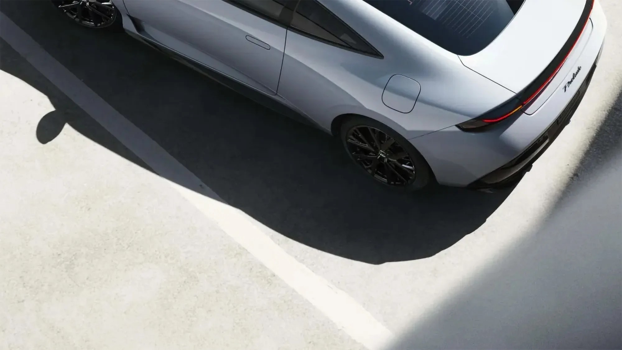 Silver Tesla Model S Plaid electric car parked in a parking lot, viewed from above.