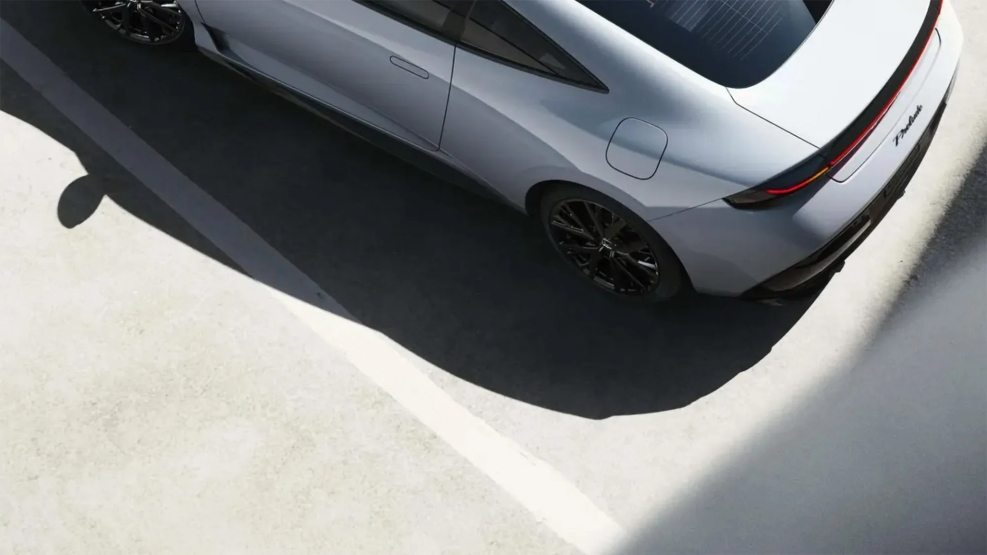 Silver Tesla Model S Plaid electric car parked in a parking lot, viewed from above.