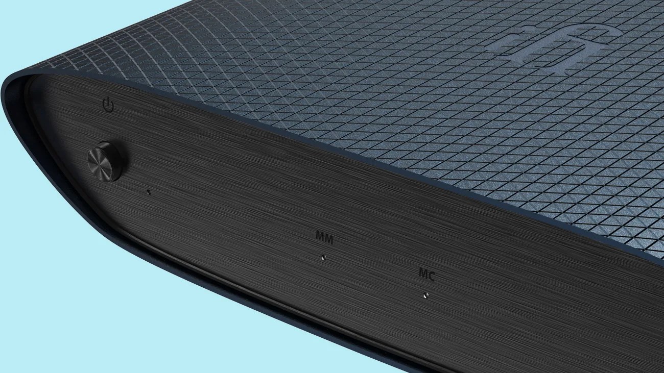 Close-up of a dark blue audio device with a textured diamond pattern and a black brushed metal front panel featuring a power button and MM/MC indicators.
