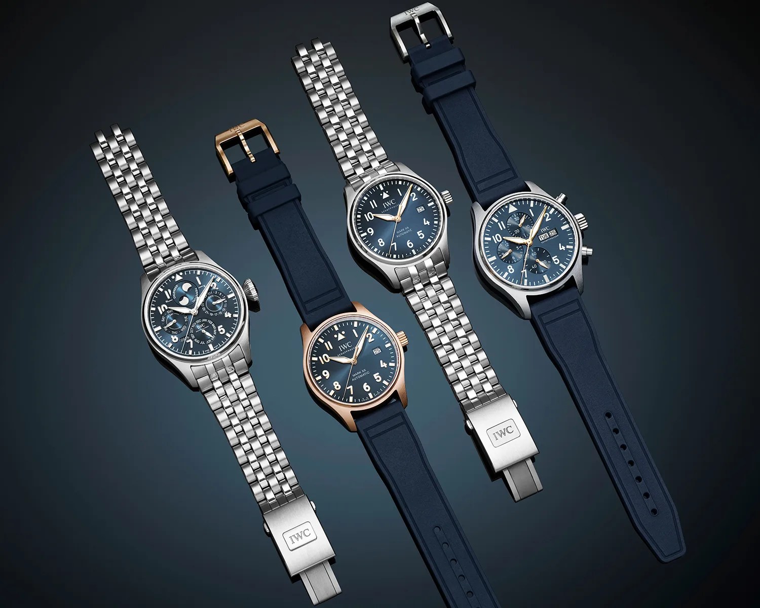 Four IWC wristwatches with blue dials, two with stainless steel bracelets and two with blue rubber straps, on a dark background.