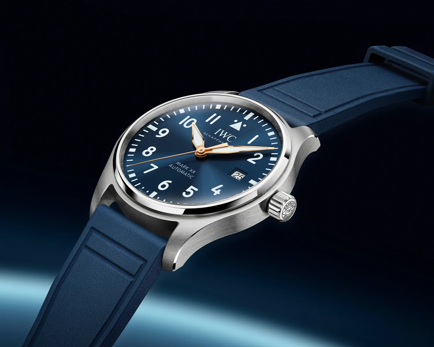 Silver IWC Mark XX automatic watch with blue dial, white numerals, gold hands, date window, and blue rubber strap.