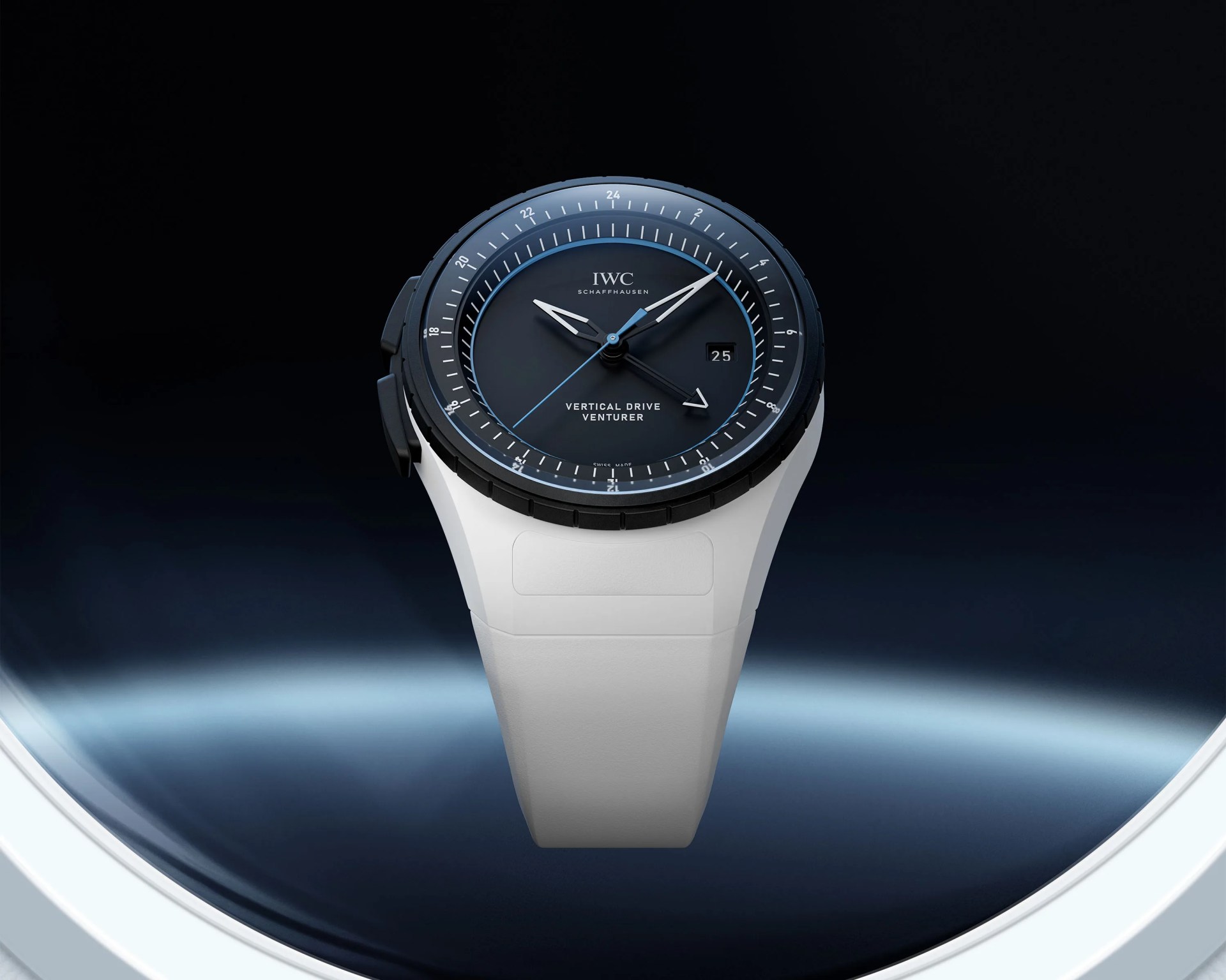 Black dial IWC Schaffhausen Vertical Drive Venturer watch with white hands and white strap against a dark blue background.