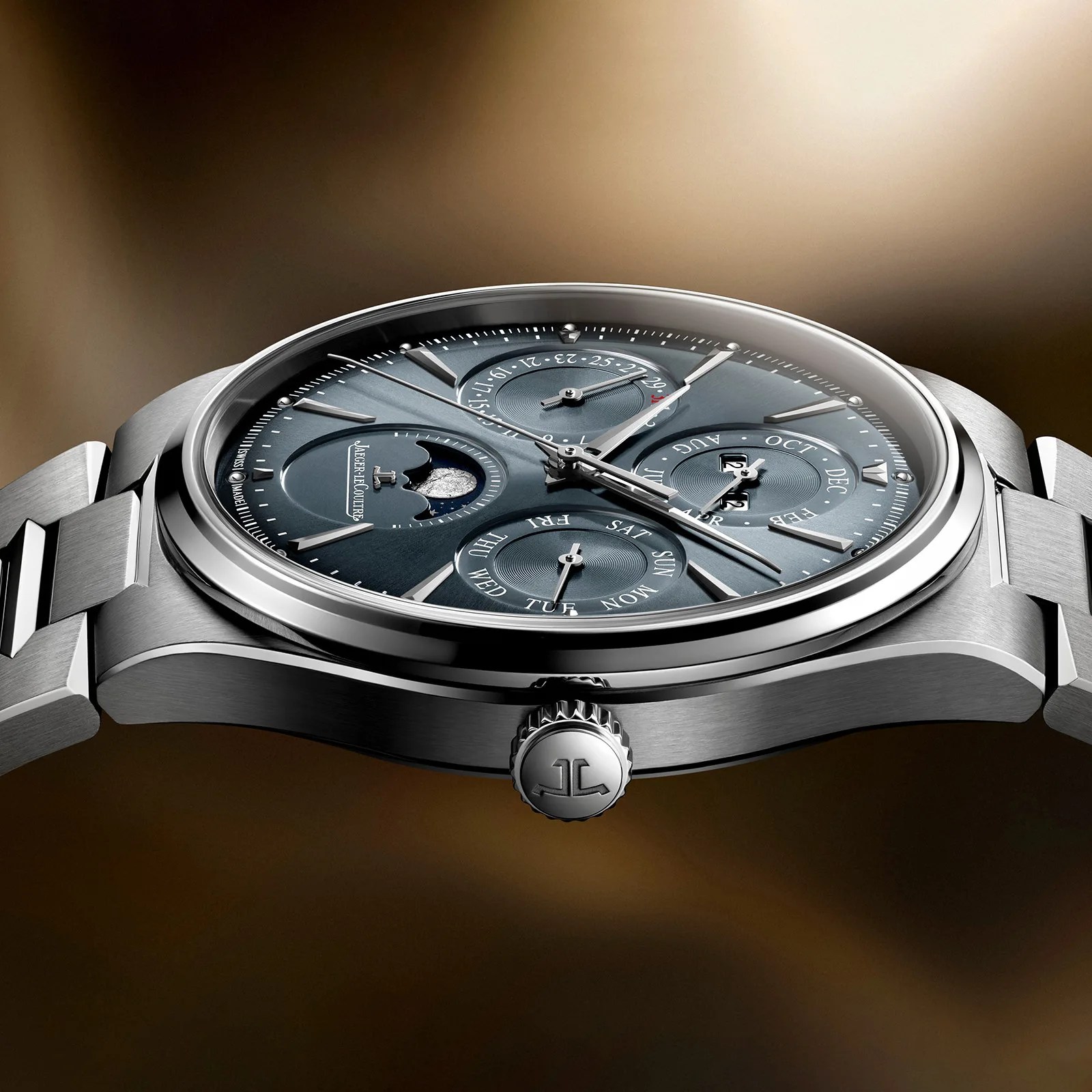 Close-up of a Jaeger-LeCoultre stainless steel wristwatch with a blue dial featuring multiple subdials and a moon phase indicator.