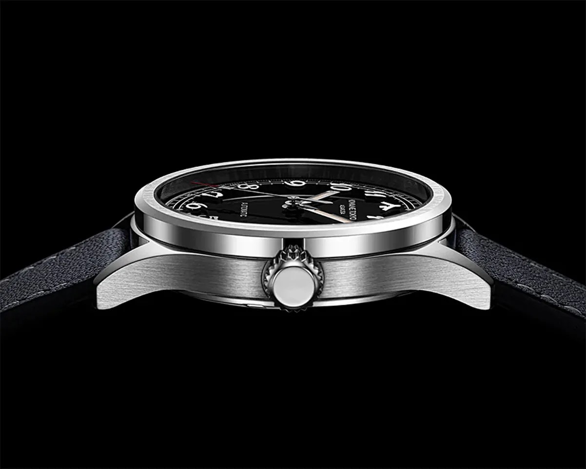 Side view of a silver stainless steel wristwatch with a black dial and black leather strap against a black background.