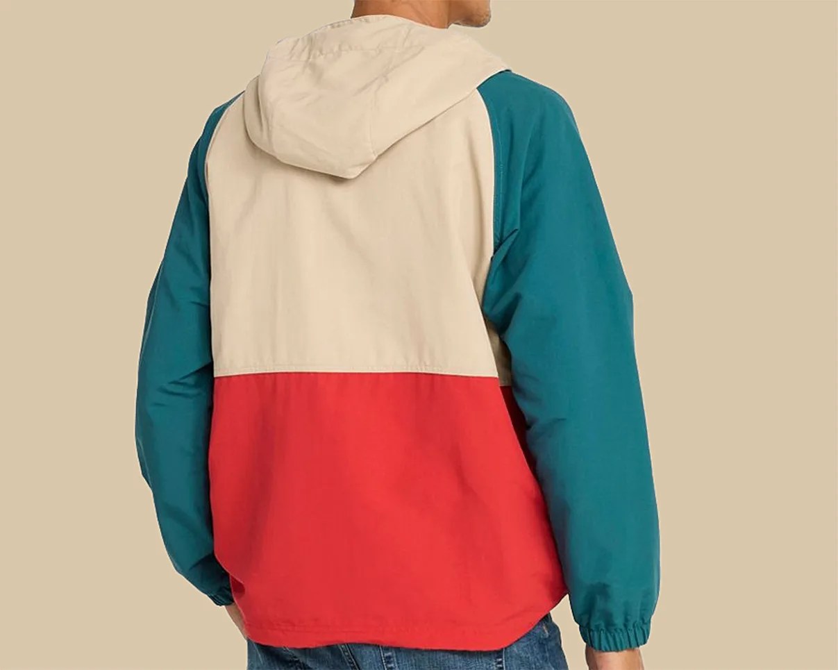 Color-blocked hooded jacket with beige upper back, red lower back, and teal sleeves worn by a person.