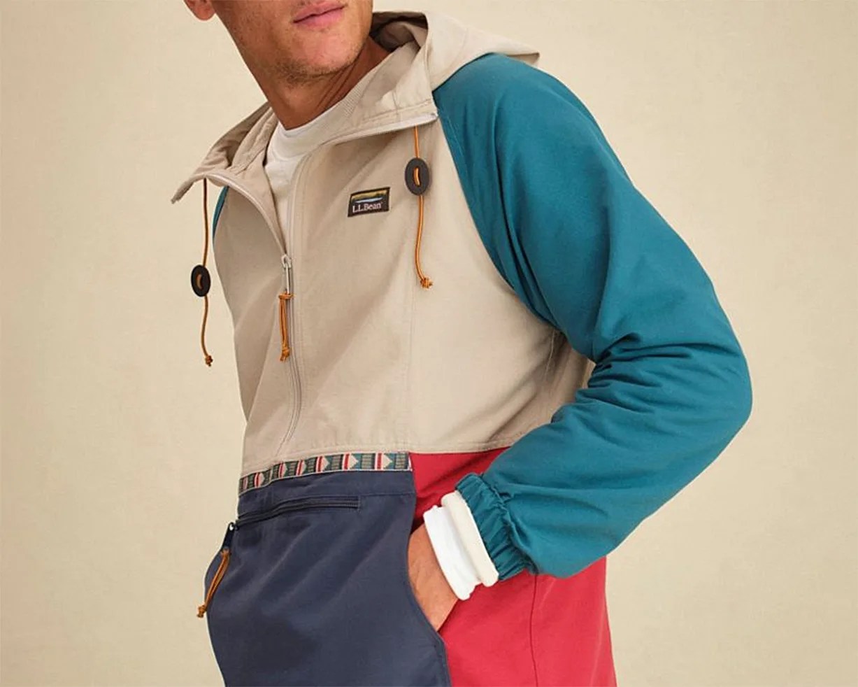 Color-blocked L.L.Bean hooded pullover with beige, teal, red, and navy sections and a front zip pocket.