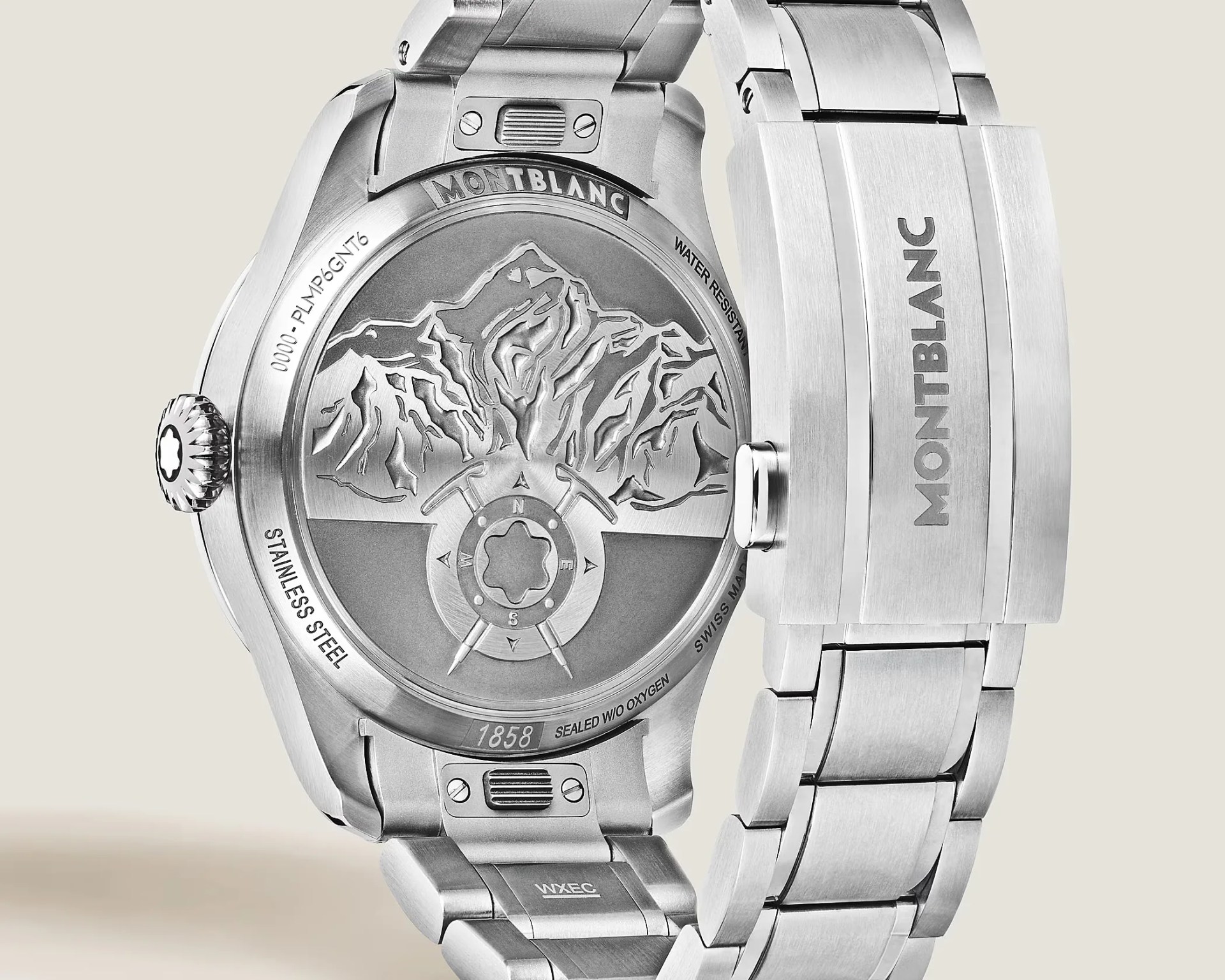 Back of a Montblanc stainless steel wristwatch with engraved mountain design and metal bracelet clasp.