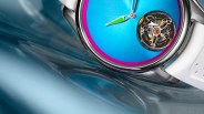 Close-up of a wristwatch with a bright blue dial, pink inner bezel, visible mechanical movement, and white strap.
