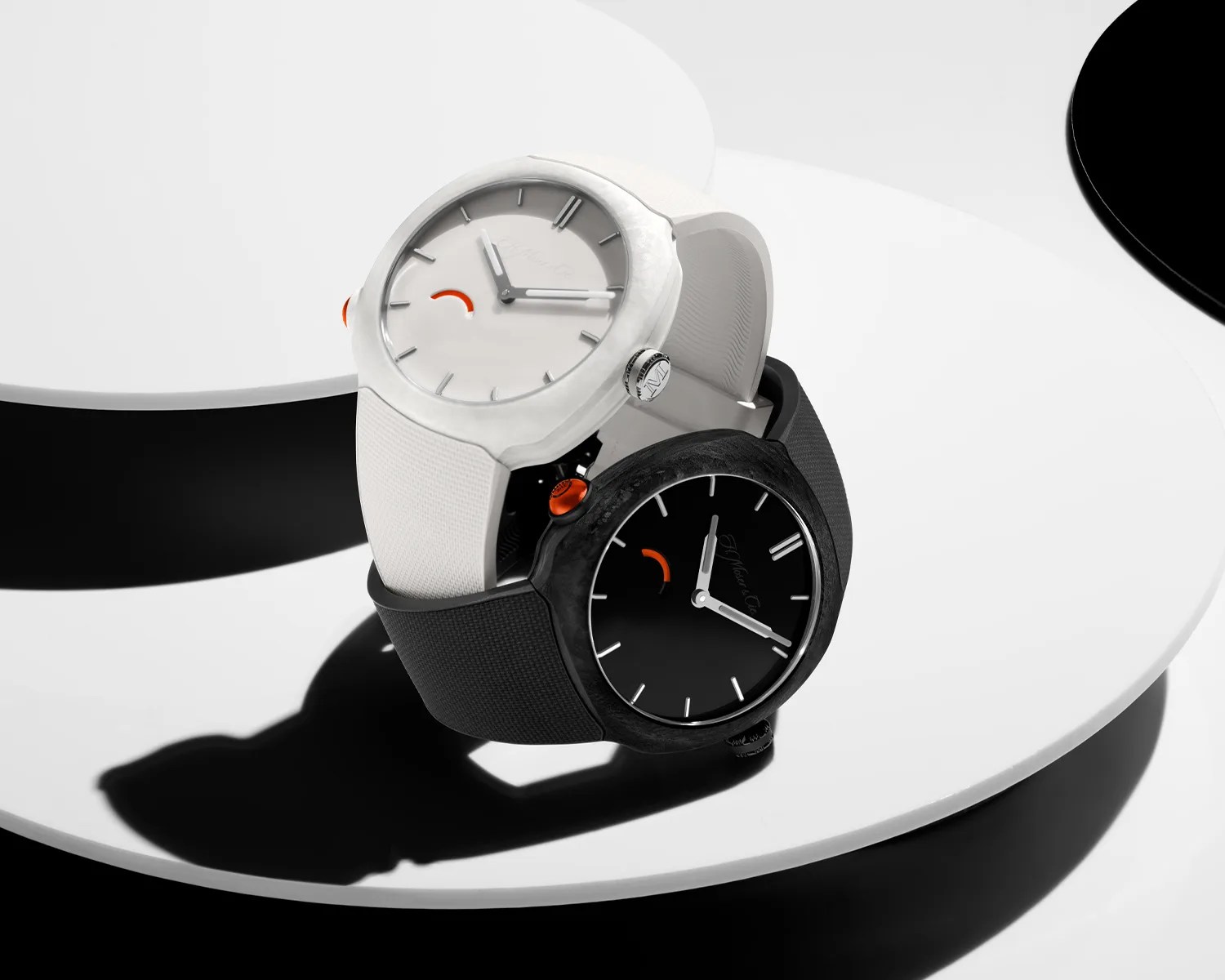 Two wristwatches with minimalist dials, one white with a white strap and one black with a black strap, displayed on a white curved surface.