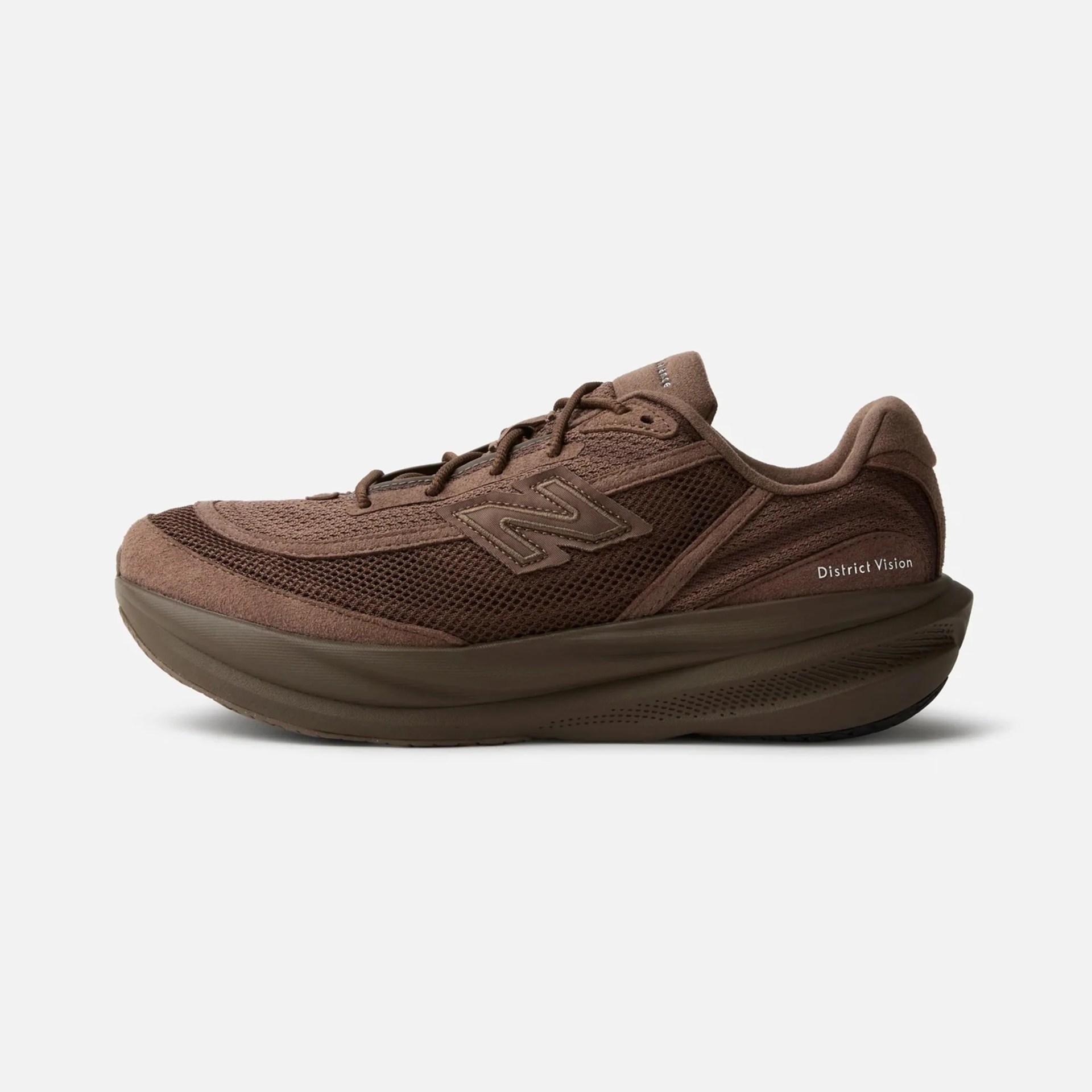 Brown New Balance sneaker with mesh and suede upper and thick cushioned sole, side view.