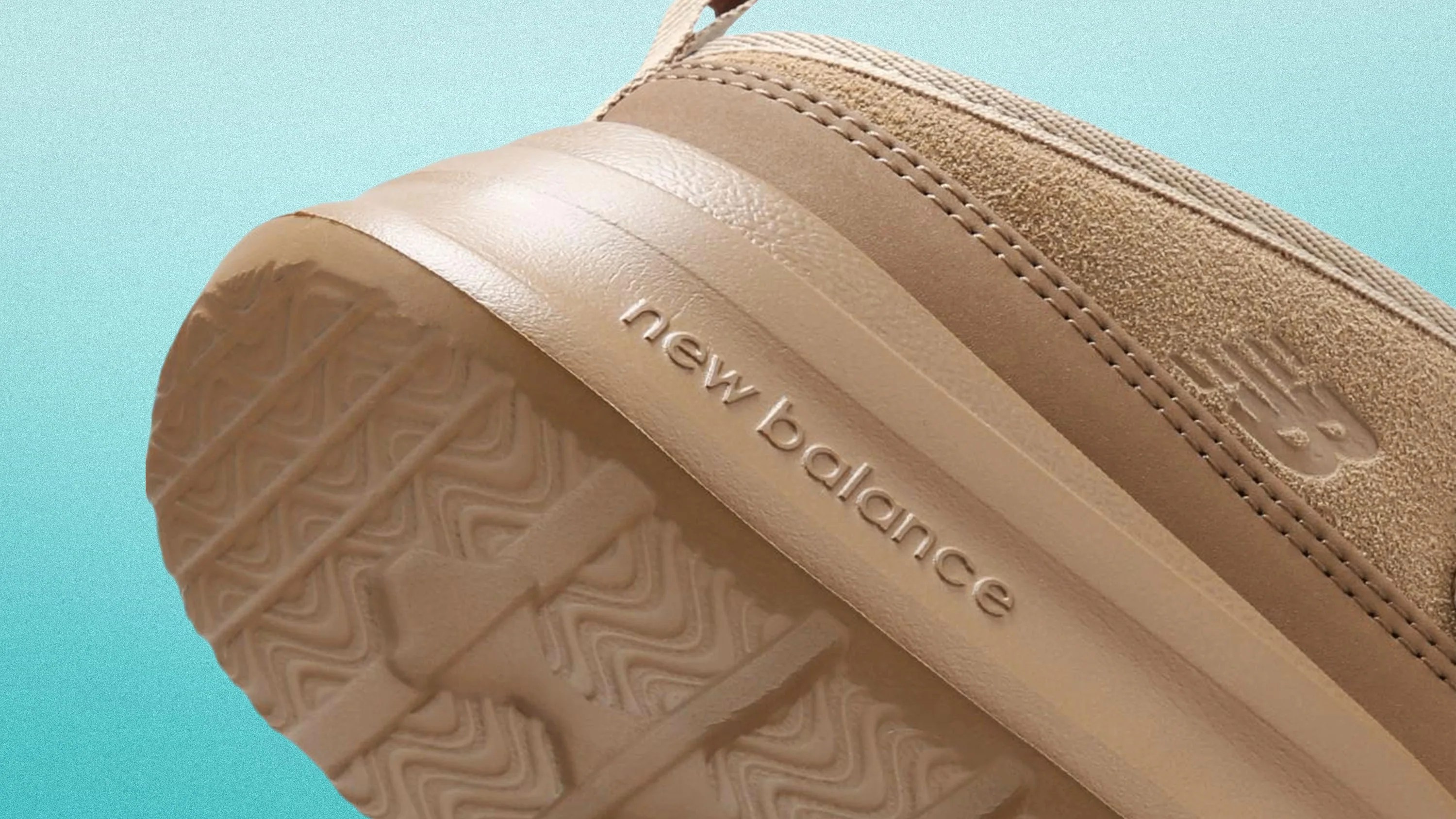 Close-up of the beige New Balance shoe sole and heel with textured tread and embossed logo.