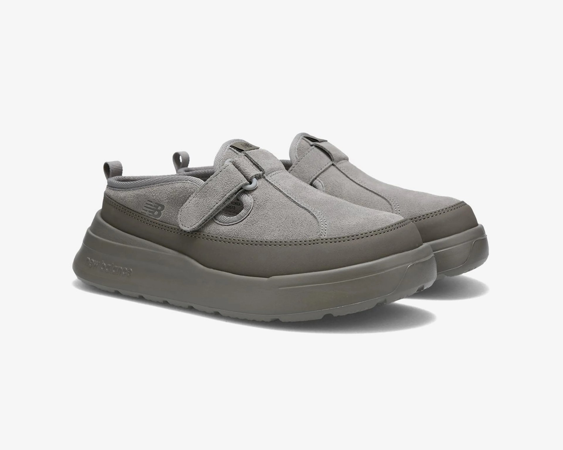 Pair of gray suede slip-on shoes with thick rubber soles and adjustable straps.