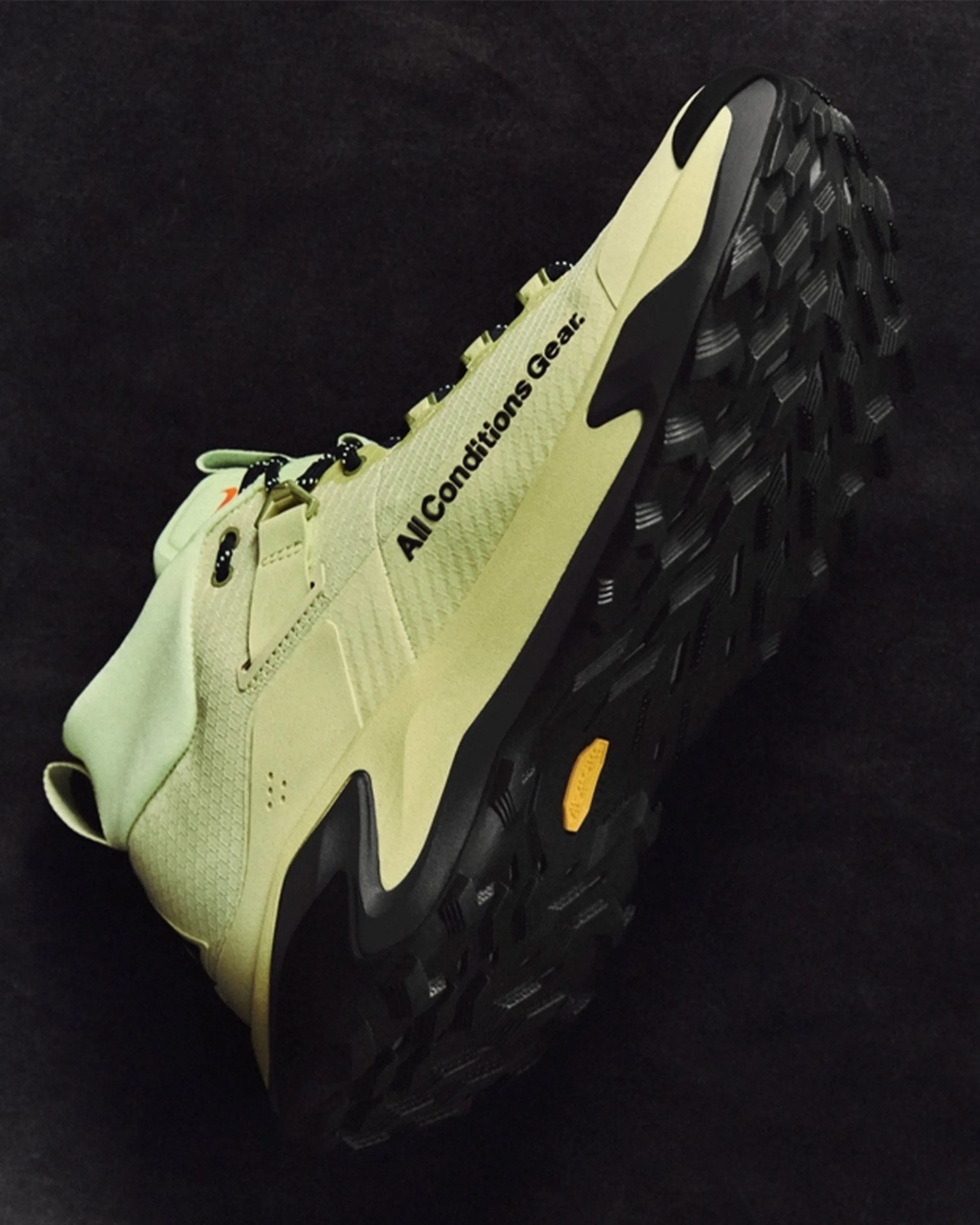 Light green hiking shoe with black rugged sole and "All Conditions Gear" text on the side.