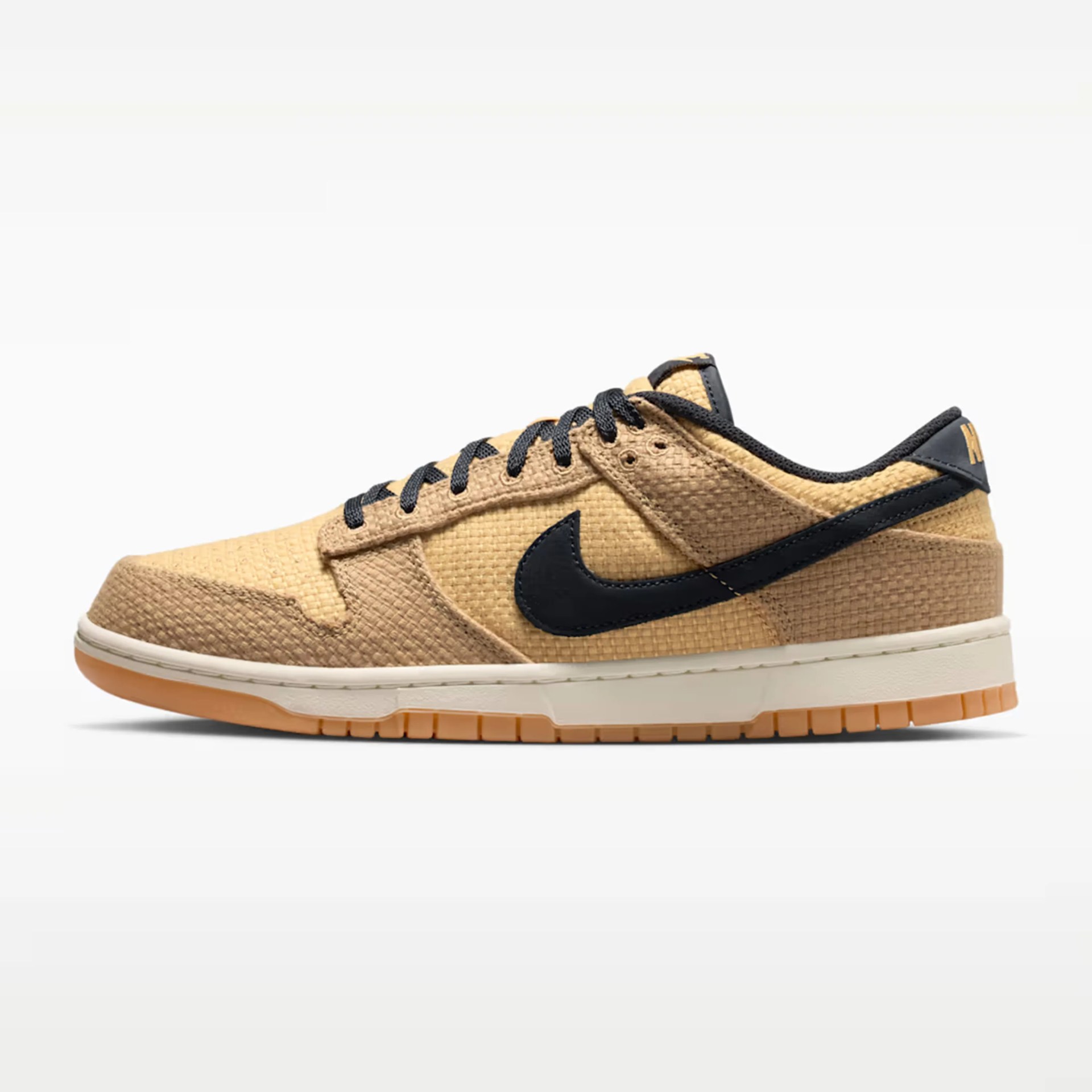 Tan and beige textured Nike sneaker with black swoosh and laces, white midsole, and gum outsole.