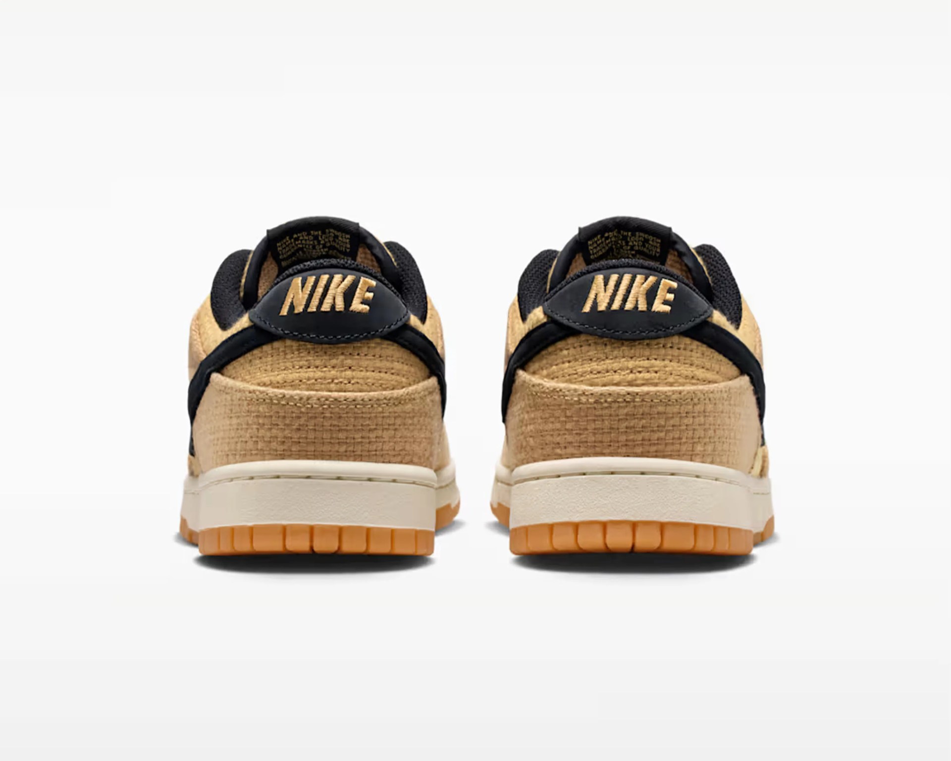 Pair of tan Nike sneakers with black accents and gum soles shown from the back.
