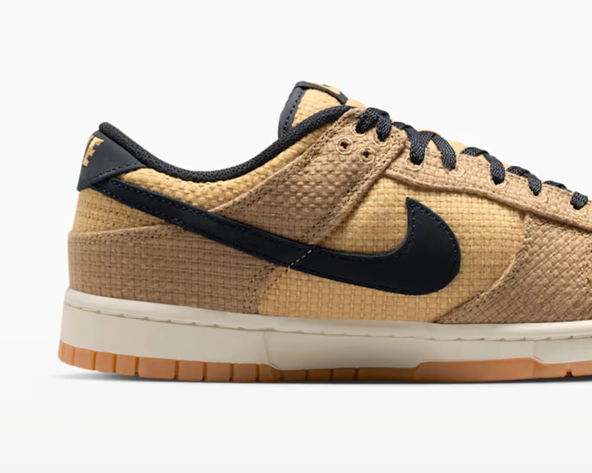 Tan textured Nike sneaker with black swoosh and laces, white midsole, and gum outsole.