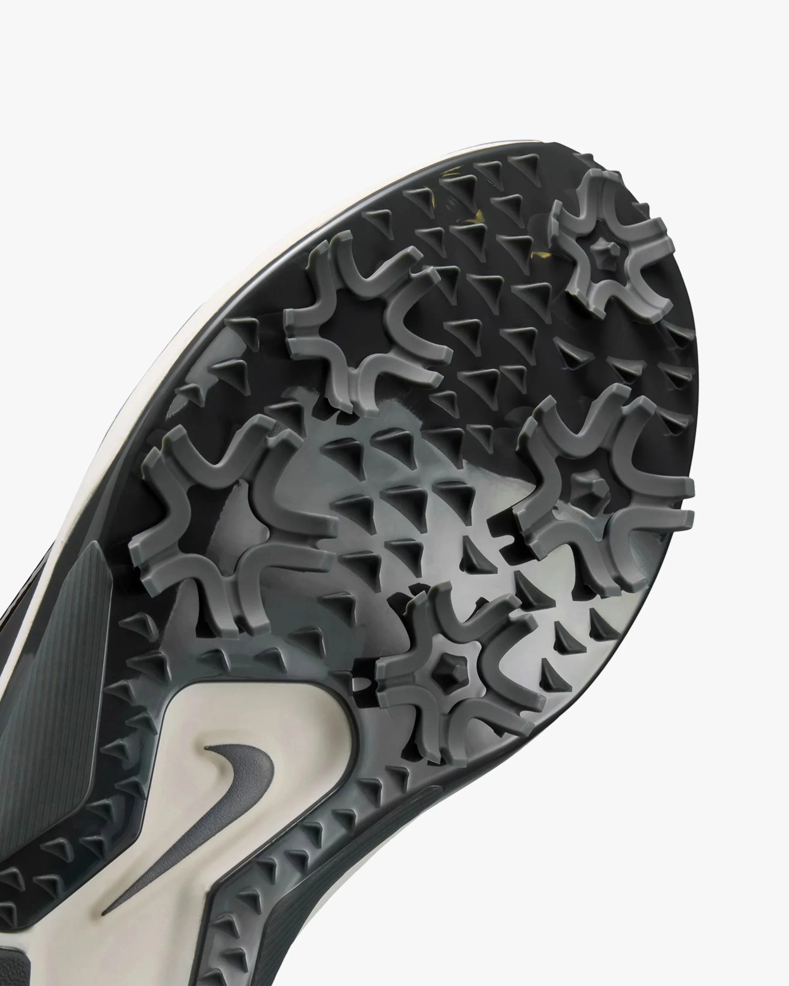 Close-up of a black and gray Nike shoe sole with star-shaped and triangular traction patterns.