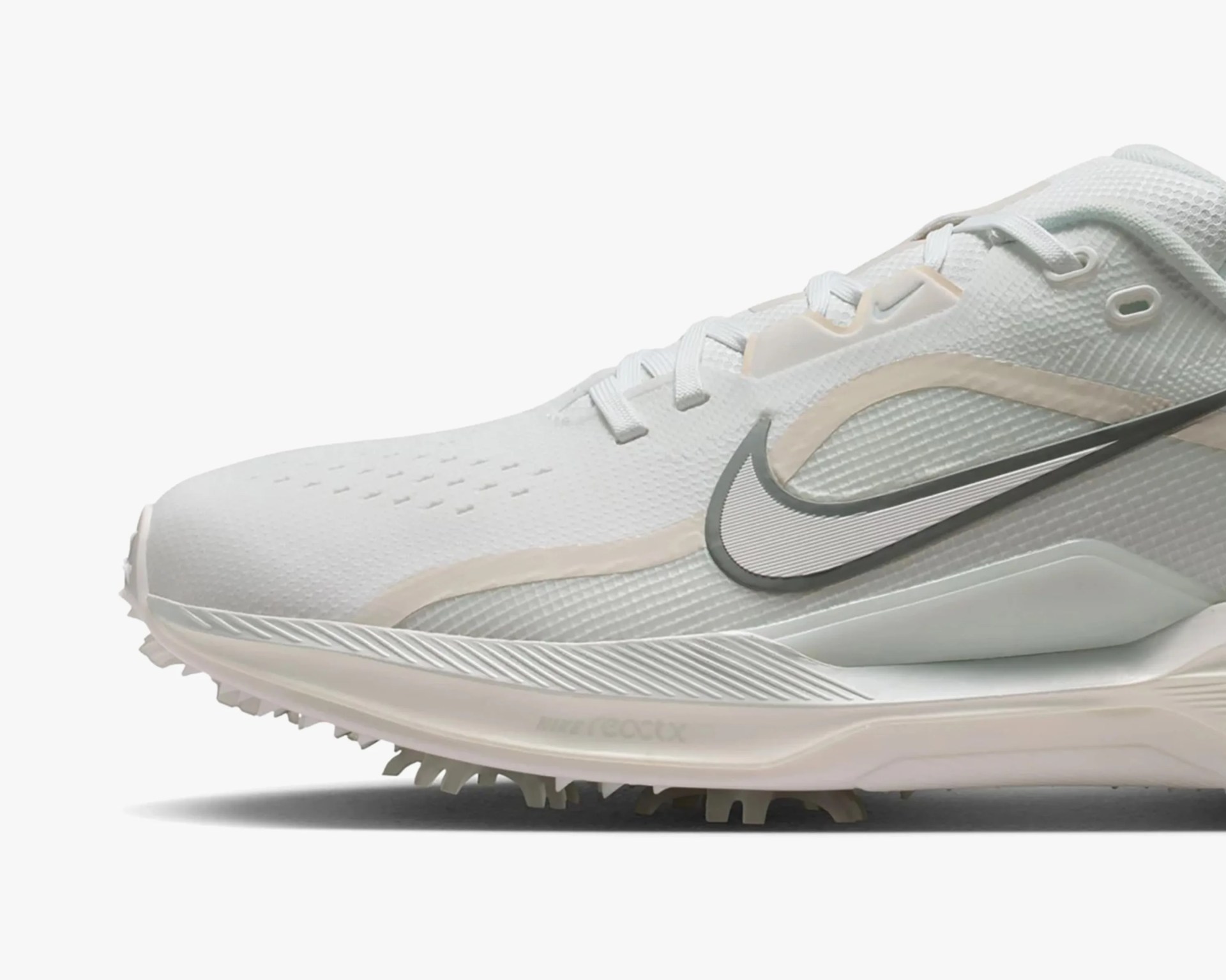 White Nike running shoe with light beige accents and a gray swoosh logo on the side.
