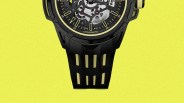Black and yellow skeleton dial watch with black strap featuring yellow accents on a yellow background.