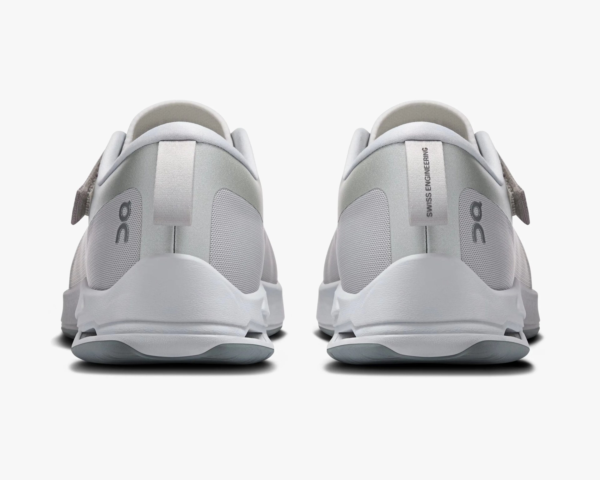 Pair of light gray athletic shoes with white soles viewed from the back on a white background.