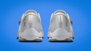 Pair of white athletic shoes with "Swiss Engineering" text on heel tabs against a blue background.