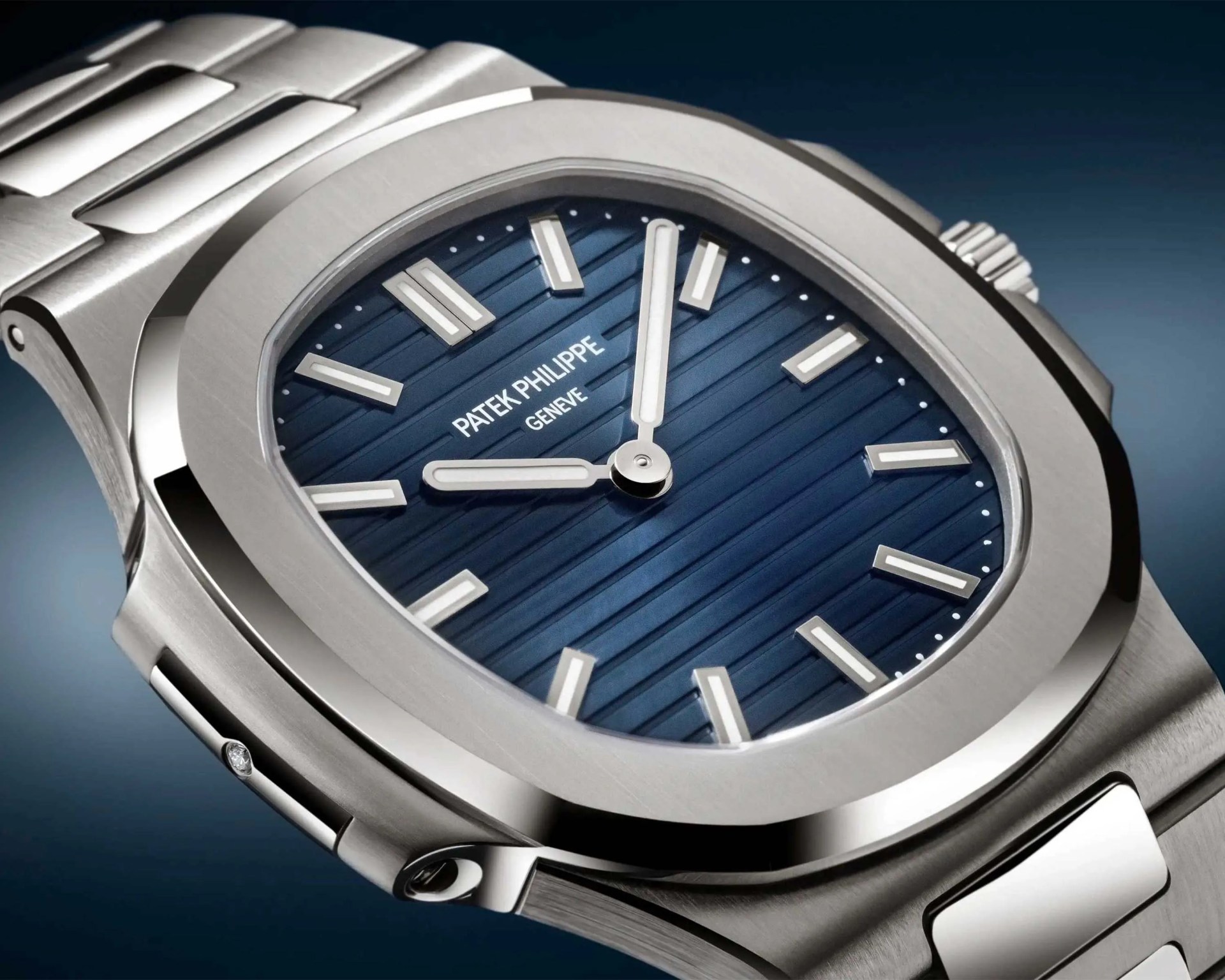 Silver stainless steel Patek Philippe wristwatch with a blue textured dial and silver hour markers.