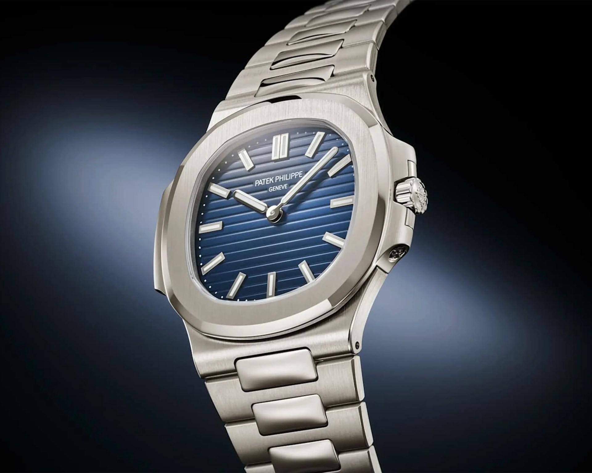 Silver stainless steel Patek Philippe wristwatch with a blue textured dial and silver hour markers.
