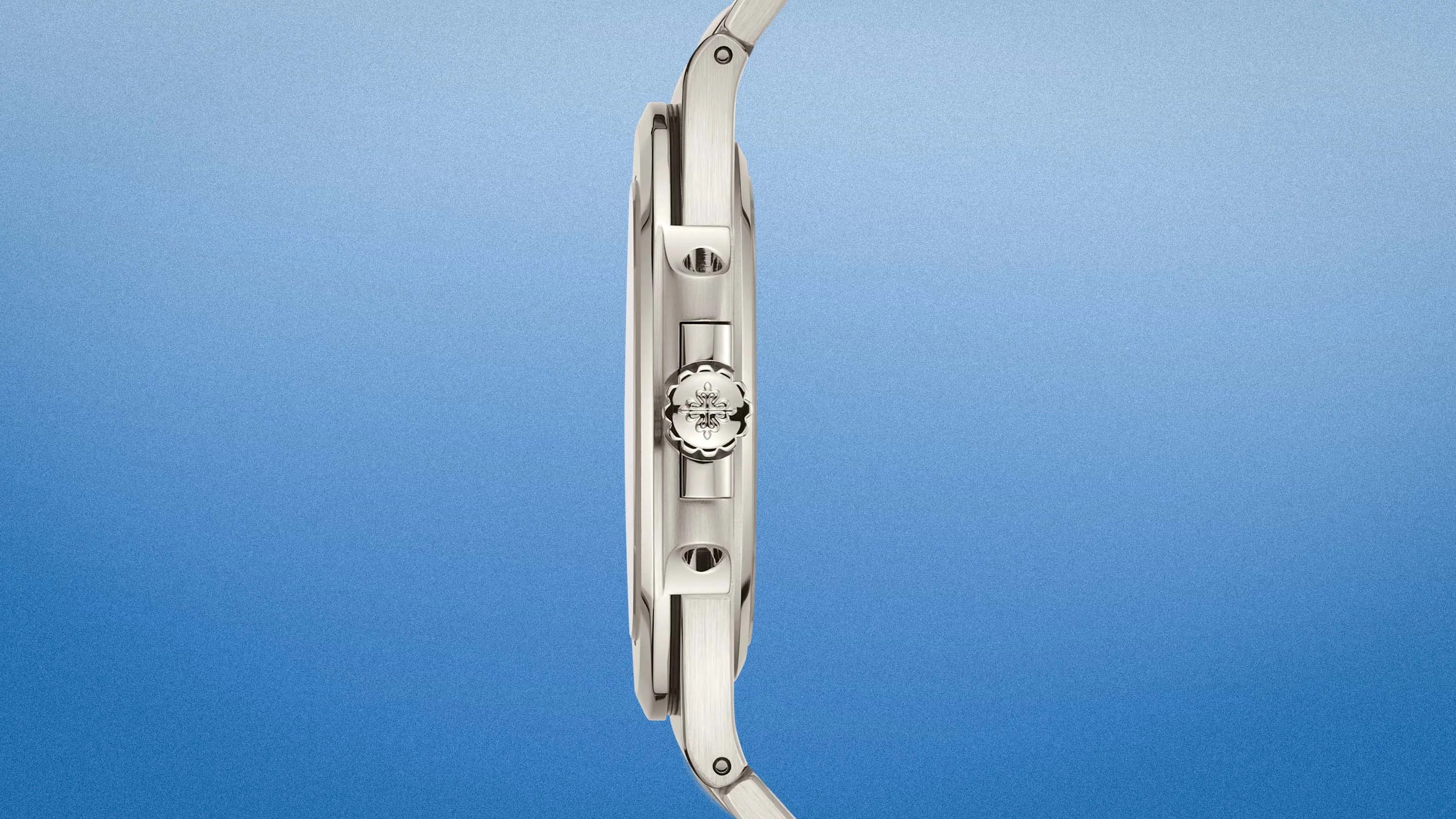 Side view of a slim silver metal wristwatch with a detailed crown and integrated lugs on a gradient blue background.