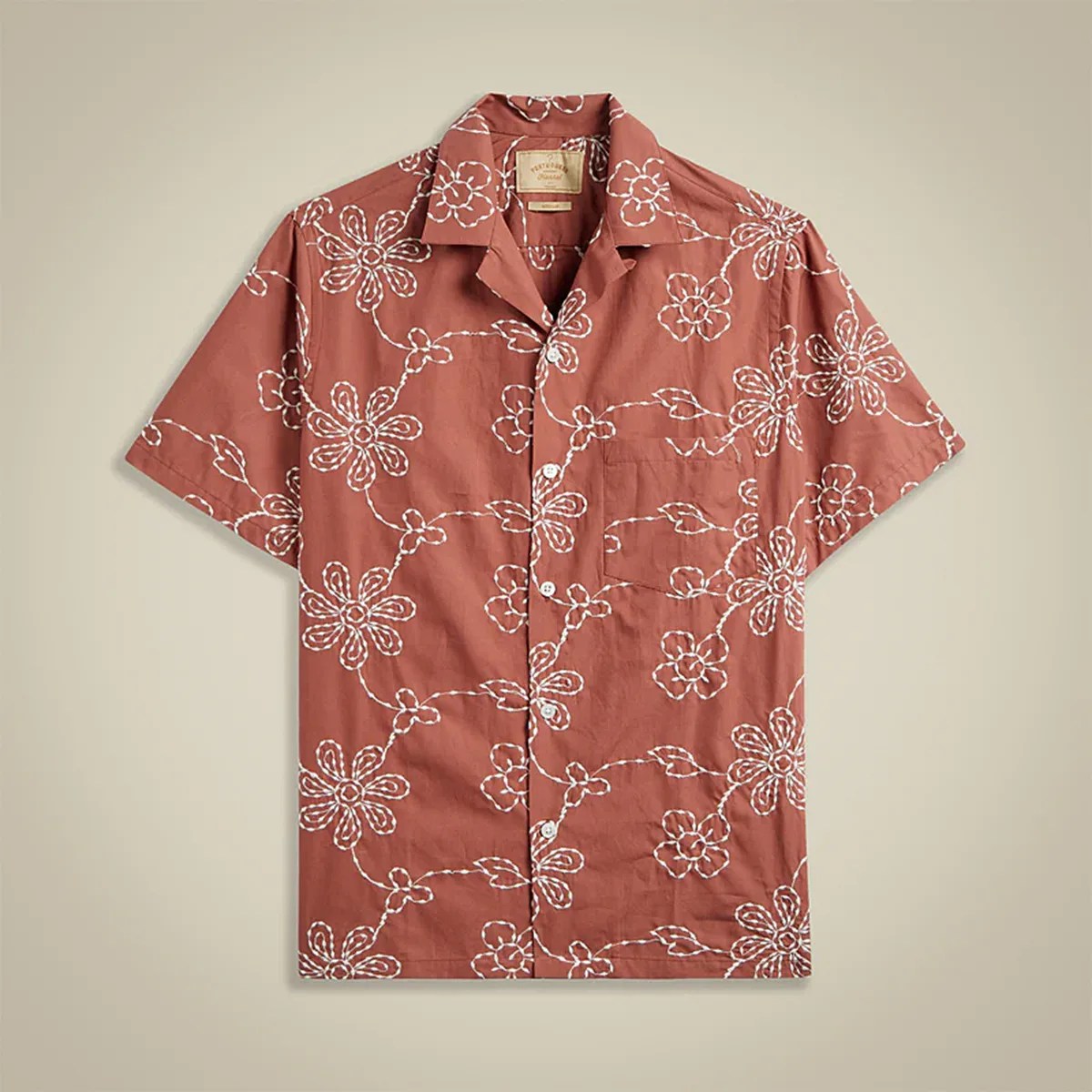 Rust-colored short-sleeve button-up shirt with white floral embroidery and a chest pocket.
