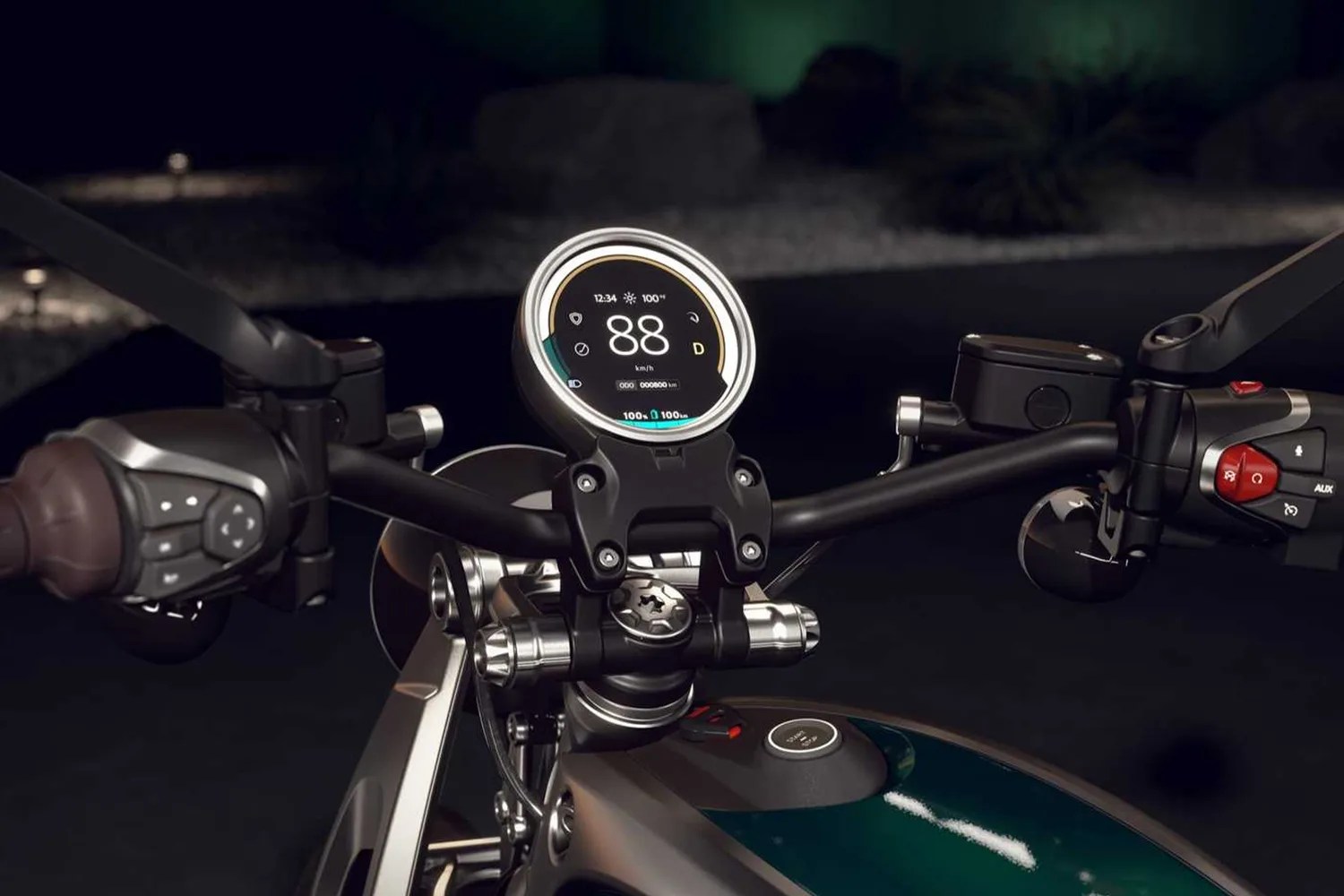 Close-up of a motorcycle handlebar with a round digital speedometer displaying 88 km/h and control buttons on both sides.