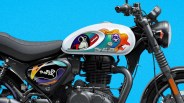 Black motorcycle with a white fuel tank featuring colorful cartoon-style graphics and a black seat.