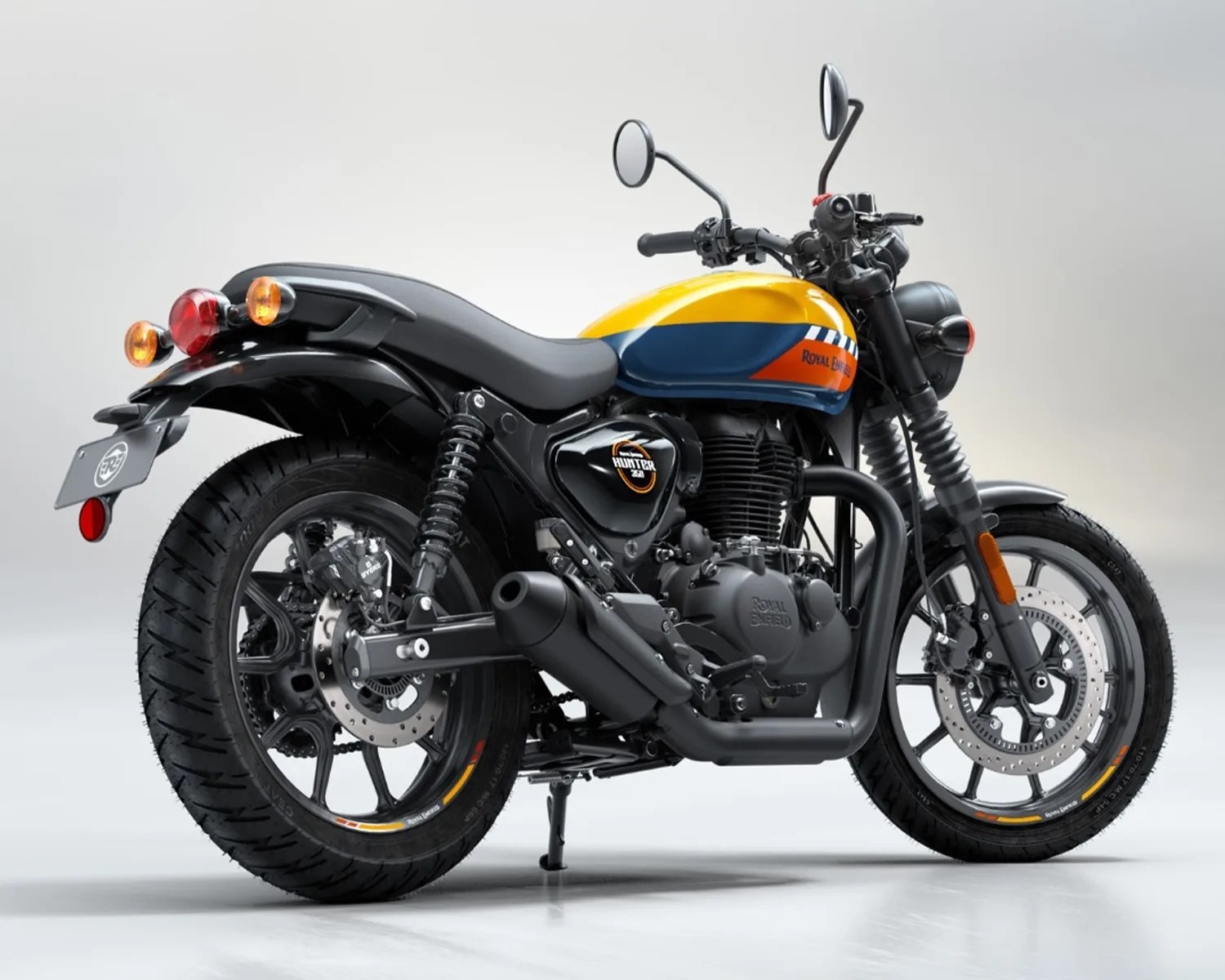 Yellow and blue Royal Enfield Hunter 350 motorcycle with black exhaust and tires on a white background.