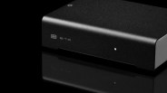 Black rectangular audio device with "EITR" logo and a small white indicator light on a reflective black surface.