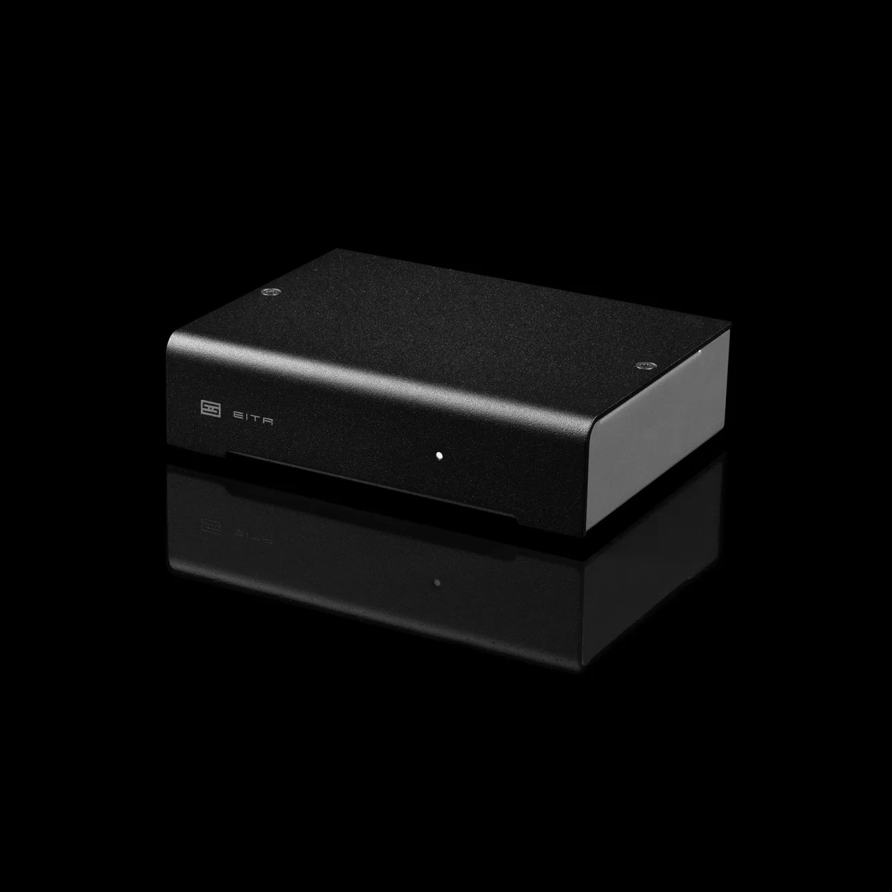 Black rectangular audio device with rounded edges and a small white indicator light on the front panel, labeled "EITR.
