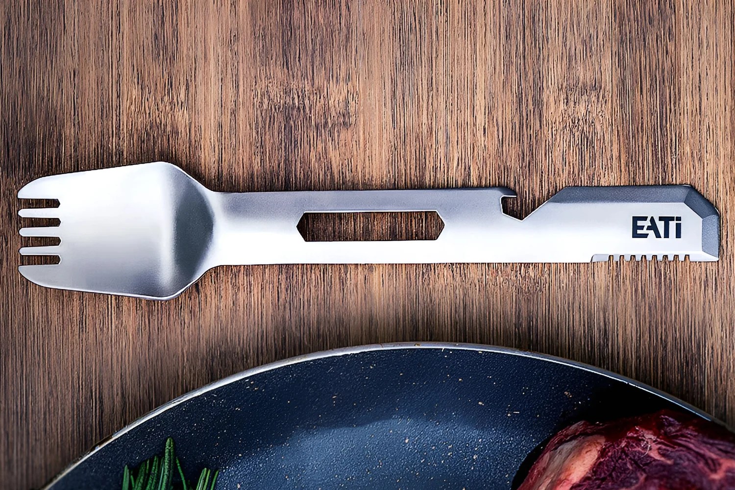 Silver multi-tool spork with bottle opener and serrated edge on wooden surface.