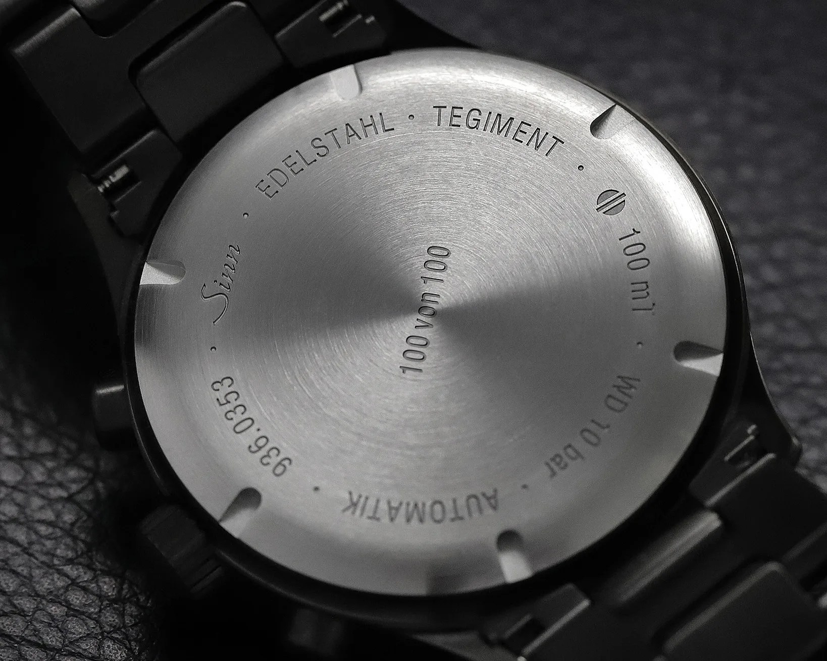 Brushed stainless steel watch back with engraved text including "Sinn," "EDELSTAHL," "TEGIMENT," and "100 von 100.