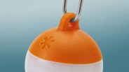 Orange and white buoy with a metal hook attached at the top against a gradient blue background.