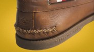 Close-up of the heel of a brown leather Sperry Top-Sider boat shoe with braided stitching and embossed logo on the sole.
