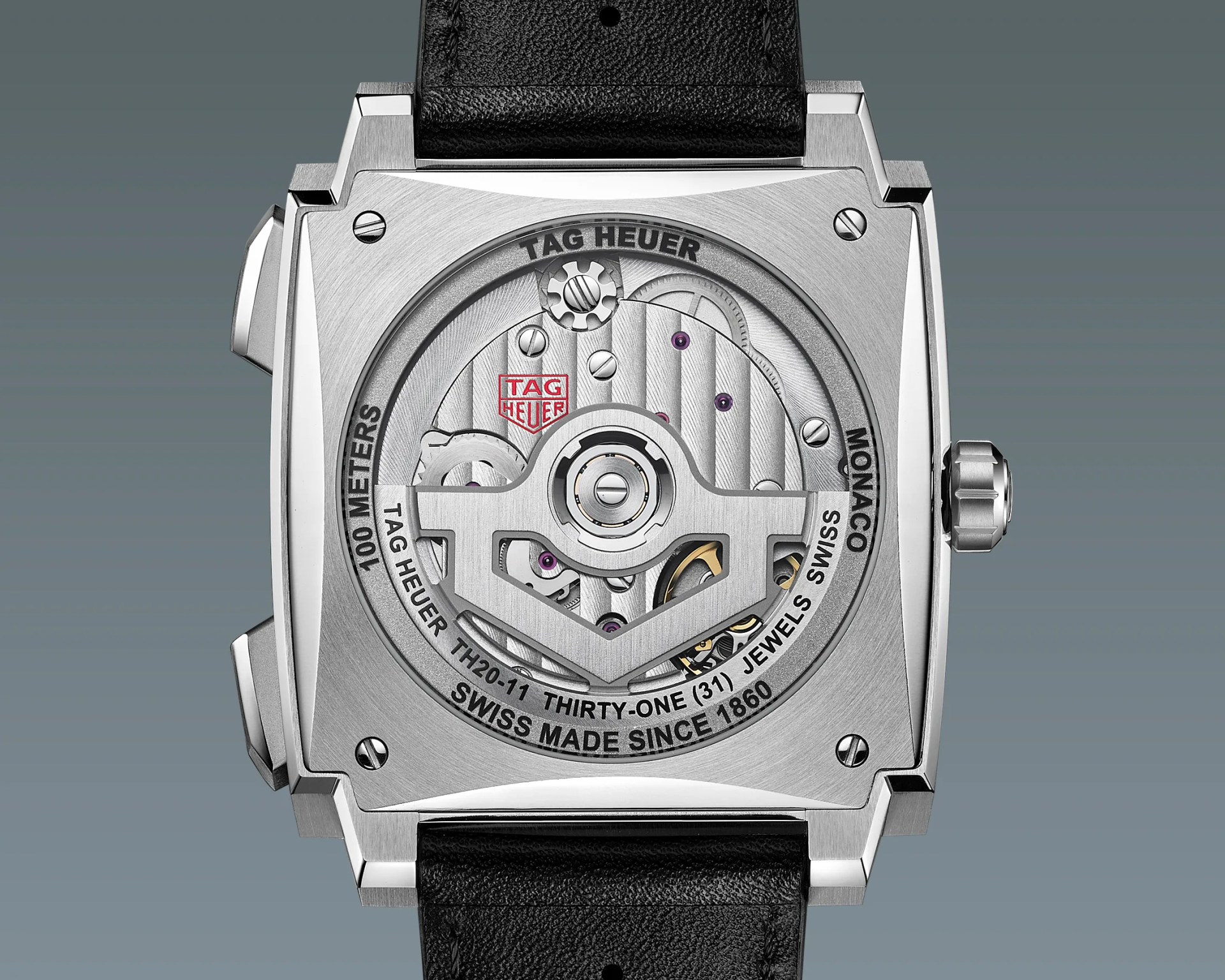Square stainless steel TAG Heuer Monaco watch back showing mechanical movement with black leather strap.