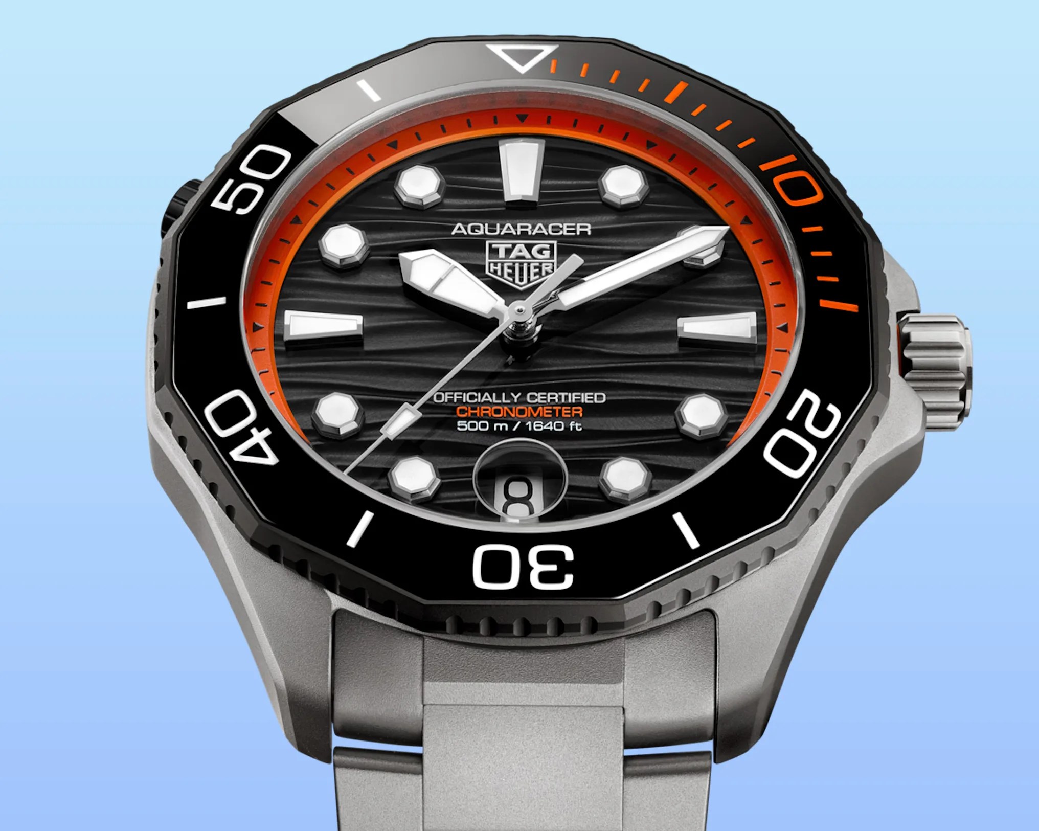 Black TAG Heuer Aquaracer watch face with orange accents and silver metal strap.