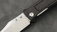 Close-up of a folding knife with a silver blade marked "Tenable" and a dark textured handle.
